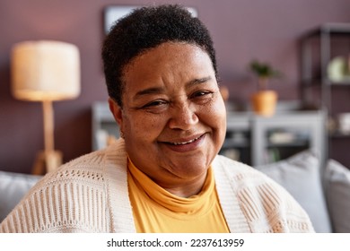 Candid close up portrait of senior woman smiling at camera in home setting - Powered by Shutterstock