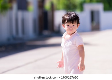 Candid cute little boy sweating on face. Happy healthy sweaty face child. Baby aged 1-2 years old. Toddler playing in the morning hot in summer day. Children turn back and looks at the camera.