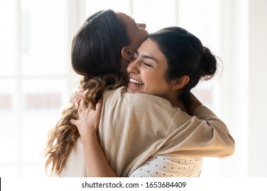 Candid diverse girls best friends embracing standing indoors, close up satisfied women face enjoy tender moment missed glad to see each other after long separation, friendship warm relations concept - Powered by Shutterstock