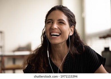 Candid Laughter. Headshot Of Overjoyed Millennial Latin Female Wearing Wired Earphones Laughing In Good Mood Showing Beautiful Even Teeth. Carefree Young Woman Having Fun Listen To Funny Joke On Radio