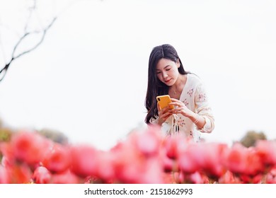 Candid Lifestyle Portrait Of Happy Young Beautiful Asian Sexy Woman Enjoying Life Outdoor In Park At Spring. Smiling Millennial Girl With Perfect Clear Glow Skin And Long Brunette Hair