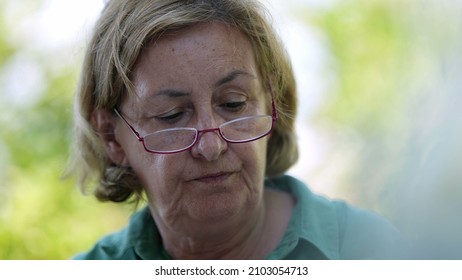 Candid Older Senior Woman Wearing Reading Glasses Outside Speaking