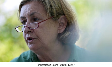 Candid Older Senior Woman Wearing Reading Glasses Outside Speaking