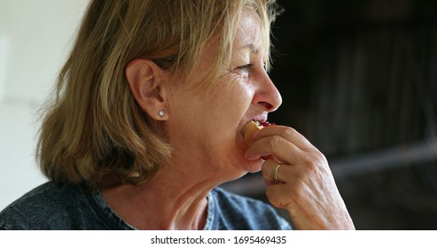 Candid Older Woman Eating Toast With Jelly Morning Breakfast.