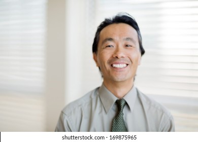 Candid out of focus shot of happy smiling doctor near window