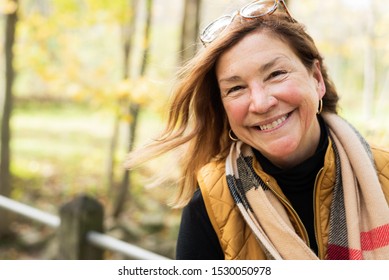 Candid Portrait Of Happy Middle Age Woman Hiking Outdoors In Autumn