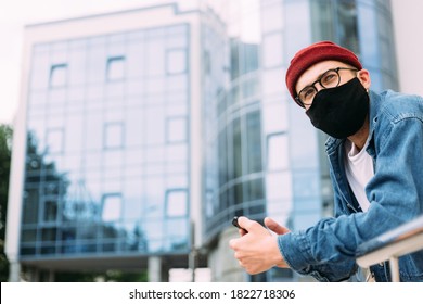 Candid portrait of male hipster wearing protective face mask and eyeglasses looking away. Blue color scheme. Copy space. - Powered by Shutterstock