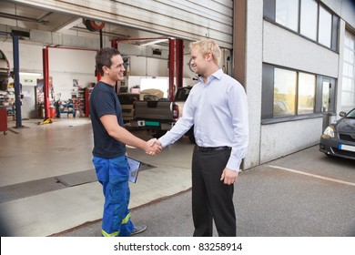 Candid Portrait Of A Mechanic Shaking Hands With Client