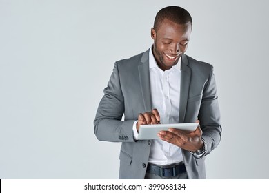 Candid portrait of positive friendly black  professional businessman with touchscreen tablet device isolated in studio