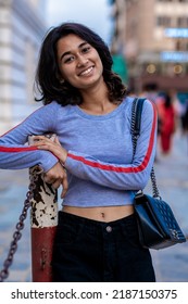 Candid portrait of a smiling young beautiful Indian Nepali girl wearing  T-shirt showing her belly button