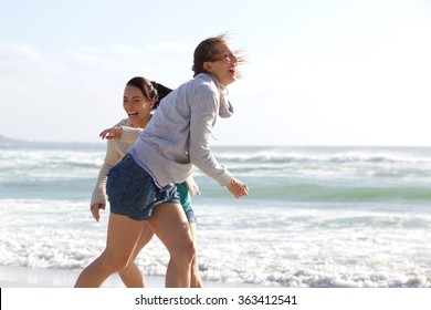 Candid Portrait Of Two Women Laughing At The Beach