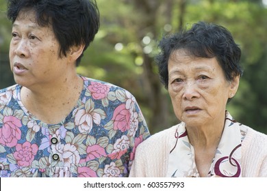 Candid Shot Of Asian Elderly Women Gossip At Outdoor Park In The Morning.