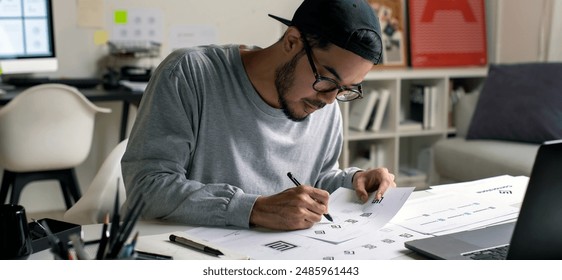 Candid shot of Asian graphic designer inspecting logo designs, using computers, designing logos, and showcasing the corporate identity and logo design process. - Powered by Shutterstock