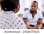 Candid shot of handsome African American male speaking with curvy female boss during office meeting