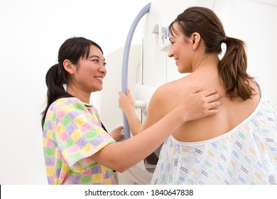 A Candid Shot Of Professional Radiologist Happily Attending A Patient On A Mammogram Machine In The Radiology Department