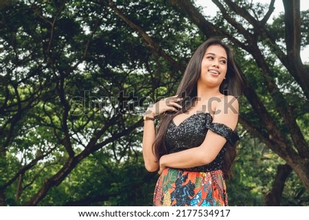 Candid shot of a voluptuous and curvy young Filipina at the park. A serious yet alluring look.