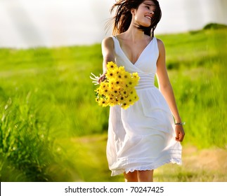 Candid skipping carefree adorable woman in field with flowers at summer sunset. - Powered by Shutterstock