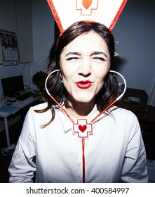 Candid Snapshot Of A Young Adult Woman Disguised As A Nurse Goofing Off In Front Of The Camera.