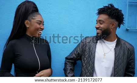 Candid two adult siblings teasing each other outside brother and sister laugh and smile