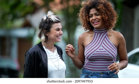 Candid Two Diverse Women Walking Together Outside In Street Laughing And Smiling