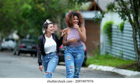 Candid Two Diverse Women Walking Together Outside In Street Laughing And Smiling