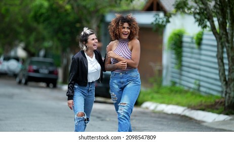 Candid Two Diverse Women Walking Together Outside In Street Laughing And Smiling