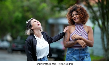 Candid Two Diverse Women Walking Together Outside In Street Laughing And Smiling