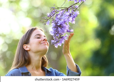 Candid Woman Smelling Flowers Standing In A Park