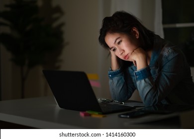 Candid of young asian single female student work late night stress out with project research problem on computer laptop or notebook at home office. Asian people occupational burnout syndrome concept.