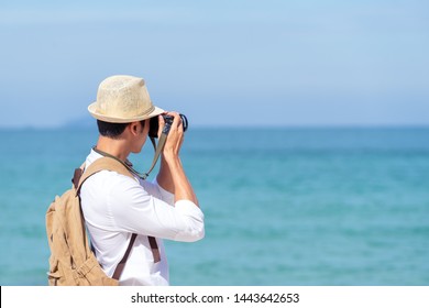 Candid of young attractive asian man hold camera taking photo in blue sky and sea view background. Happy asian hipster male photographer in youth freedom culture lifestyle travel in rear view concept. - Powered by Shutterstock