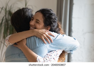 Candid young Hispanic woman in love missed of beloved man hugs tight express love feels affection look very happy. Romantic relationship, reunion after a long separation, marriage proposal day concept