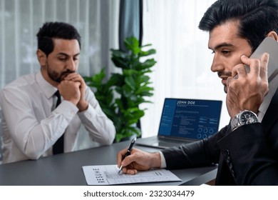 Candidate feeling dissatisfied and lose confidence during job interview as interviewer talk on the phone, ignoring and showing disinterest. Negative interview experience for applicant. Fervent - Shutterstock ID 2323034479