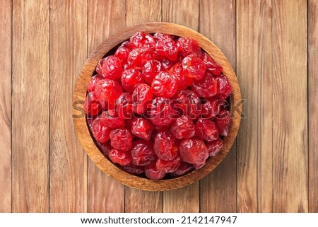candied fruit, dried cherry with sugar in wooden bowl on  background of table. healthy vegetable food.