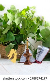 Candle, angel, bible book and green birch leaves on table. Holy Trinity Sunday. festive traditional composition for Pentecost day. concept of faith, God, orthodox Church, lent, religion
