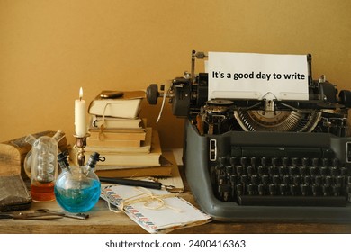 candle burning in candlestick, stack old books, letters, vintage typewriter with good day to write, creative process and literary creation, atmosphere journalism and reportage, antiques and collecting