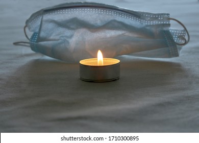 A Candle Burns Next To A Protective Mask In Memory Of The Victims.Memorial Day