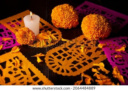 Candle with Cempasuchil orange flowers or Marigold. (Tagetes erecta) and Papel Picado. Decoration traditionally used in altars for the celebration of the day of the dead in Mexico