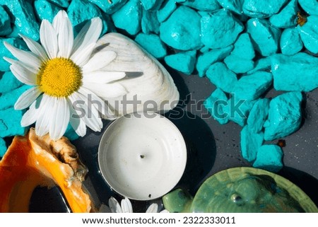Candle, chamomile and blue stones. View from above. Close-up