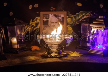 Candle in front of a portrait of a deceased person in cemetry.
