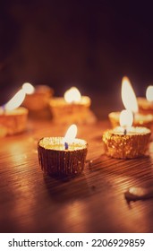 Candle With Glowing Flame Lit On Diwali Night With Selective Focus Isolated On Wooden Table With Candlelight Background In Vertical Orientation, Deepavali Or Happy Diwali Festival Celebration