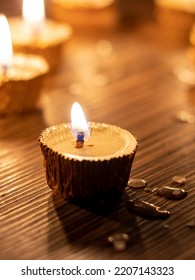 Candle With Glowing Flame On Diwali Night With Selective Focus Isolated On Wooden Table With Candlelight Background In Vertical Orientation, Deepavali Or Happy Diwali Festival Celebration Conceptual