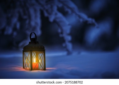 Candle lantern in snow at dusk. Christmas time in a wintery garden. - Powered by Shutterstock