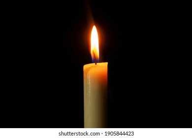 Candle Light Burning Brightly In The Black Background.