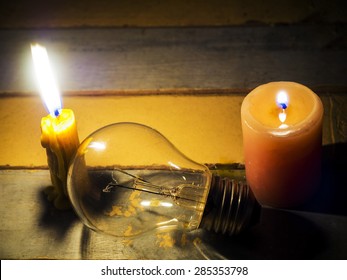 candle light shine on incandescent bulb; no electricity makes electrical equipment useless