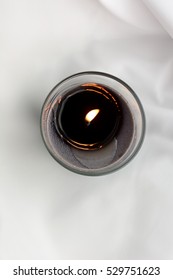 Candle Light Top View On A White Silver Background. Silk Texture. Spa Concept. Candle Flame Fire Light. Light Background. Paraffin Candle. Artistic Candle Light. Candles On A White Background. Photo