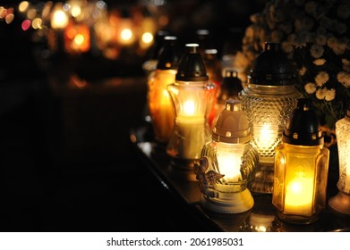 Candle lights on graves and tombstones in cemetery at night in Poland on All Saints’ Day or All Souls’ Day or Halloween or Zaduszki or Day of the Dead