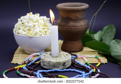 Candle Lit In A Candomblé Courtyard Beside The Sacred Leaves Of Guinea And An Offering Of Popcorn To The Orixá Oxalá.