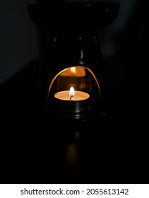 Candle Lit In A Candle Holder With Reflection In A Dark Room