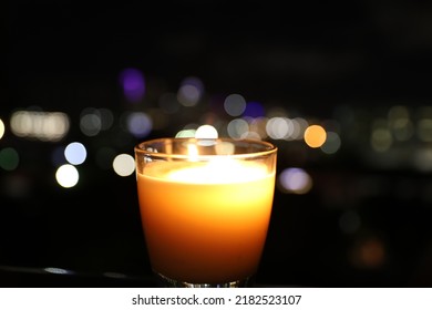 Candle With A Night Time City Scape In Boca