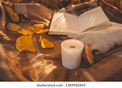 Candle and open book in nature, autumn concept. - Powered by Shutterstock